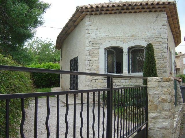 View from other side: gate, parking space for a car, very small and narrow garden, french window to living-dining room, kitchen window and bedroom1 window