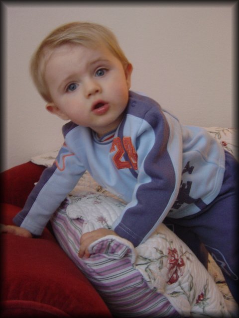 Alexis bending on the armrest of the couch, a quizzical look on his face