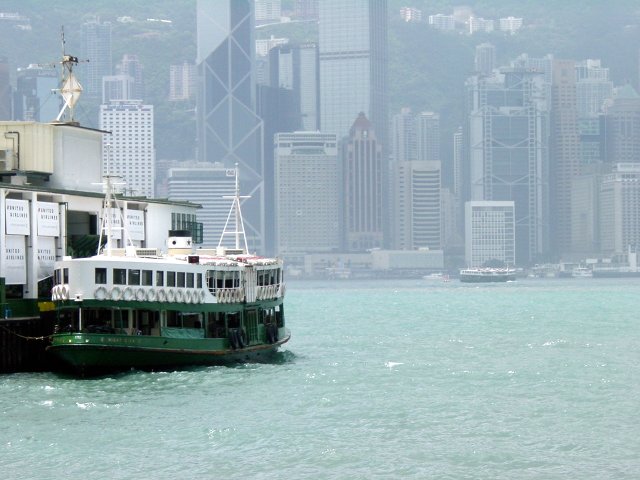 Ferry boat moored at Kowloon, HK island in the background