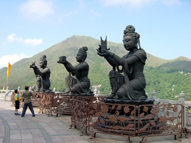 Three statues guarding the Buddha
