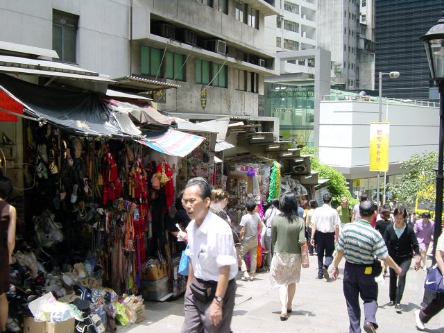 Cluttered shop by a descending street busy with people