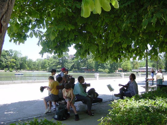 Enfants sur un banc aplaudissant un guitariste