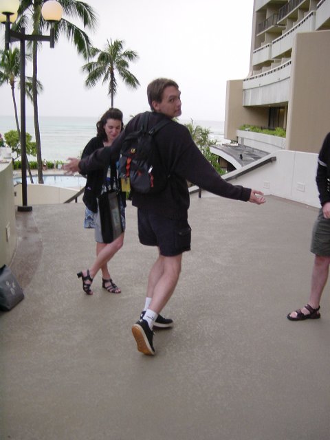 Max performing a model walk, Christelle and Hugo watching and laughing in the back