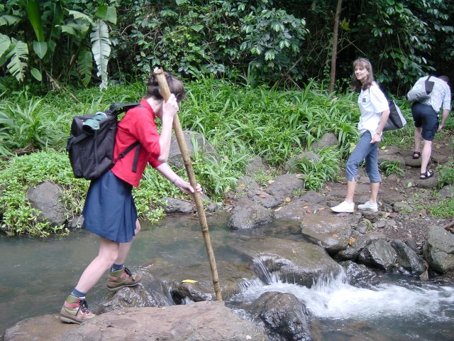 Christelle holding the stick to cross the stream, Caroline, Daniel