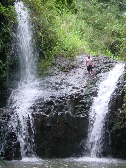 Daniel standing up above the water, between the falls