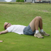 Dean sprawled in the grass, a hat over his face