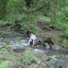 Daniel waiting for the girls sitting on a boulder by a stream