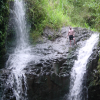 Daniel standing up above the water, between the falls