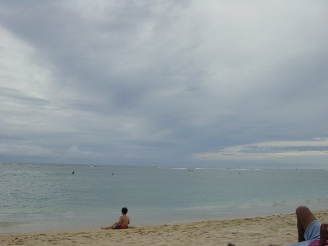 Little boy sitting near the water