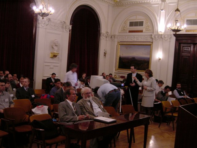 People filling the event room, people preparing the computer and lcd projector