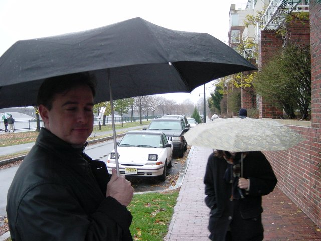 Yves under an umbrella and Carine hidden under an umbrella