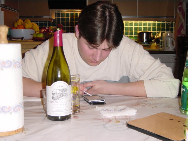 Bi joue au solitaire sur le clie', encadre' par la bouteille de vin vide et les digeo