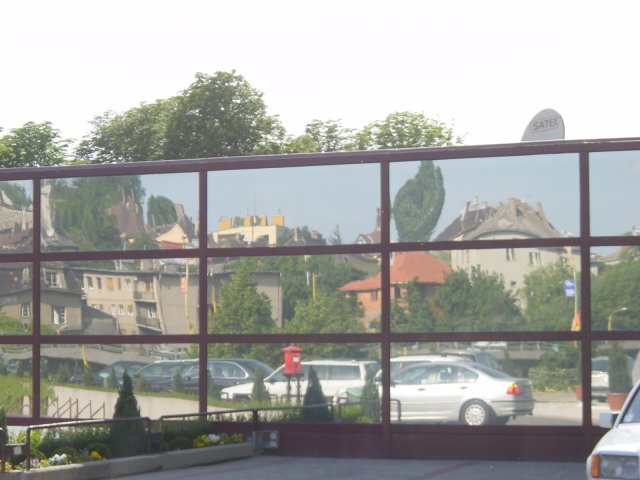 Reflection of houses and cars in a large mirror at Novotel BCC