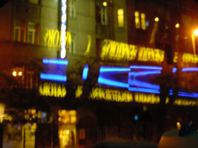 Double reflects of restaurant lit letters in the bus window