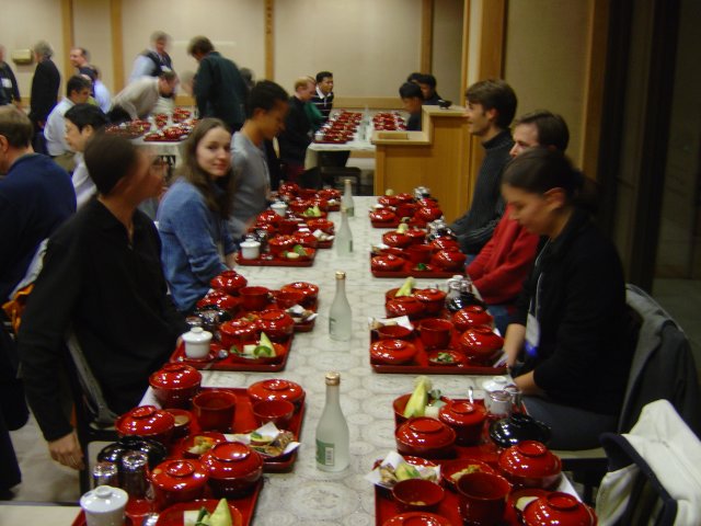Vegetarian dinner time: the dinner is served in red and black wooden bowls. Olivier, Carine, Dom, Karl, Yves, Alexandra seated.