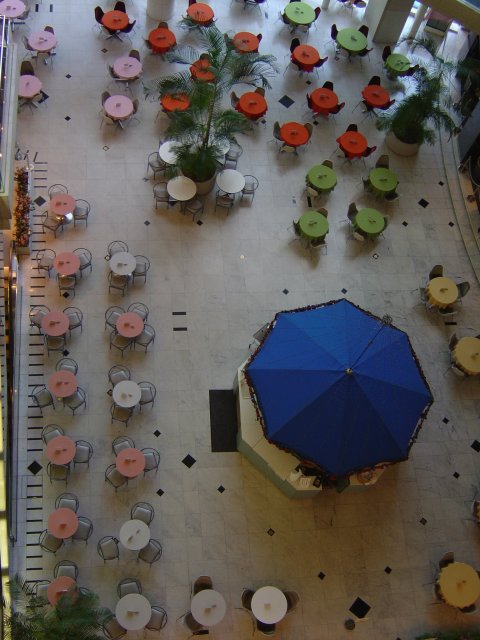 Coloured dots: View from the 5th floor on a large umbrella and tiny coloured tables