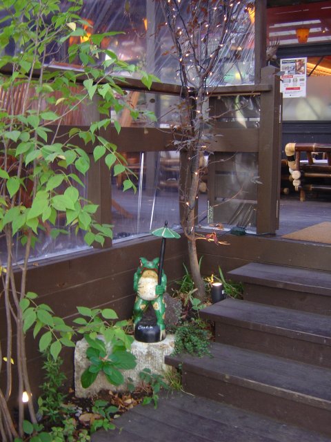 Trees and a ceramic frog holding an umbrella