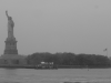 Liberty island: the statue on the left, an american flag on the right