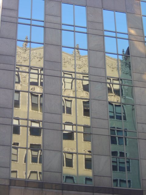 Reflection of an old building in a new building