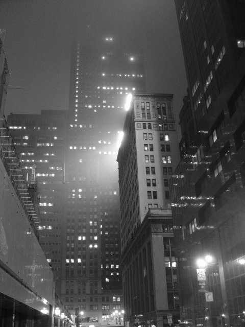 Night view on buildings surrounded by a giant cloud