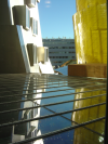 Glass surface with beads of water reflecting coloured parts of the Stata Center