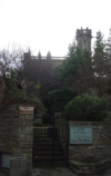 Grey church behind a garden behind an iron gate