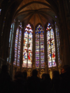 A group of people looking at huge stained-glass windows
