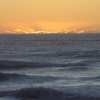 Orange sunset over a grey indigo Tasman Sea