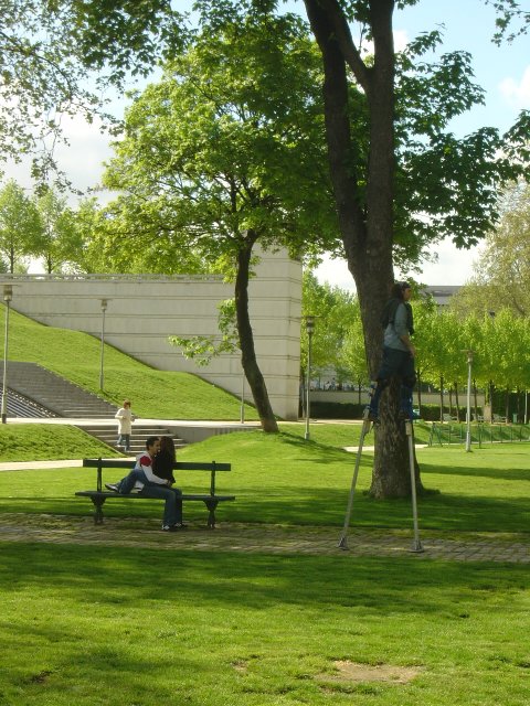 Man on stilts, couple on a bench