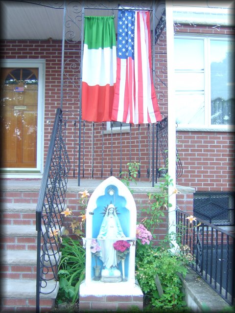 Madonna and Italian and American flags in the front of a house 
