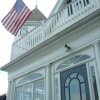 American flag above the entrance of a large white house