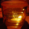 A pint of amber cider, lit by a candle