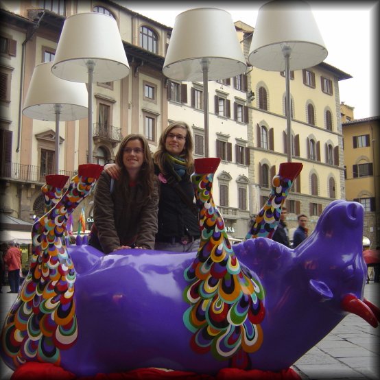 Two girls posing behind an upside down cow with lamps, Firenze