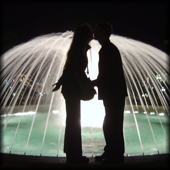 ericP and I kissing in front of a brightly lit fountain, Monaco