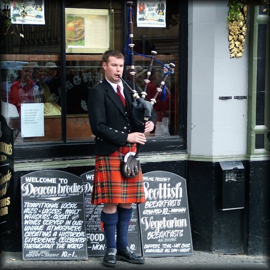 Bagpiper piping in front of Deacon Brodie's on the Royal Mile.