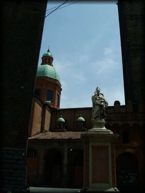 Statue between the two towers. Towers from the 12th century on Piazza Ravegnana. Torre degli Asinelli is the straight one and it's 97,20 m. high. Torre Garisenda is the slanted one and it's 47 m. high.