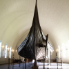 The Oseberg Ship at the Viking Ship Museum.  <em>The Oseberg Ship was found in a large burial mound at the Slagen farm in Vestfold and excavated in 1904. The ship was built in around 815-820 A.D. and had been used as a sailing vessel for many years before it was put to use as a burial ship for a prominent woman who died in 834. The ship, built of oak, was 22 meters long and 5 meters wide. The 12 strakes were secured with iron nails. The ship was designed for both rowing and sailing. With a square sail of about 90 sq. m., it could reach speeds of over 10 knots. The top strake had 15 oar holes.</em>  <em>The skeletons of two women were found in the grave. One, aged 60-70, suffered badly from arthritis and other maladies; the second was aged 25-30. It is not clear which one was the most important in life, or whether one was sacrificed to accompany the other in death. Although the high-ranking woman's identity is unknown, it has been suggested that it is the burial of Queen Asa of the Ynglinge clan, mother of Halfdan the Black and grandmother of Harald Fairhair. This theory is now generally dispelled, and it is now thought that she may have been a priestess.</em>
