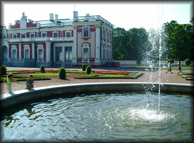 Children playing near the water of a fountain in the Kadriorg Palace garden.