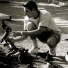 A teenager boy befriending pigeons in the Kadriorg Park.