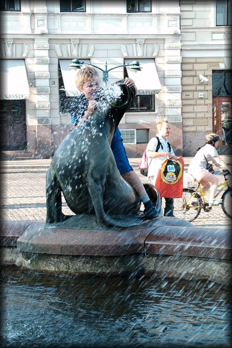 Kid wrestling one of the seals of the fountain.