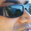 Reflections of the ocean and trees in Arun's sunglasses.