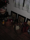 Emu sitting in a large brown paper bag near the christmas tree and presents