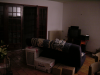 Vue depuis le fond du salon: grande fenetre a gauche, clic-clac de dos, cartons non encore ranges, meuble tv/hi-fi