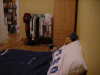 Vue depuis le fond de la chambre: lit, porte, portant, armoire