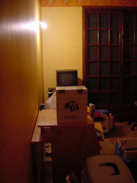 Depuis l'entree du bureau: bureau, tele, cartons, fenetre