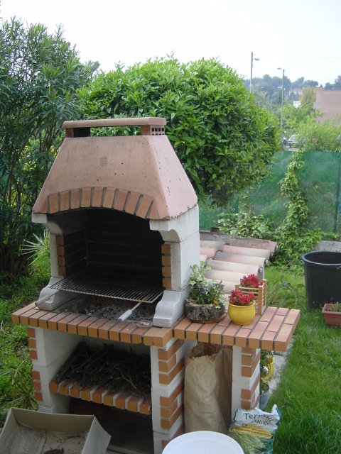 Barbecue en pierre, laurier a gauche, oranger derriere