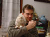 Stephane boit son the', impassible avec le chat installe' sur son epaule et son bras