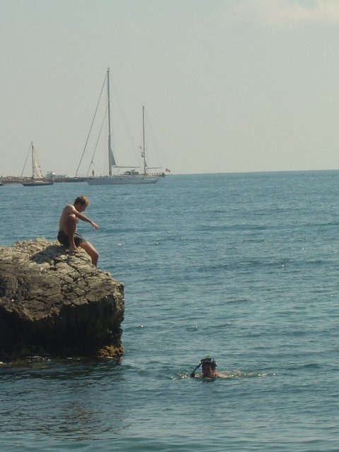 Nico s'assied sur le rocher, Guillaume est dans l'eau a cote