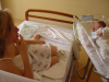 Christine allongee sur son lit et Alexis dans son berceau