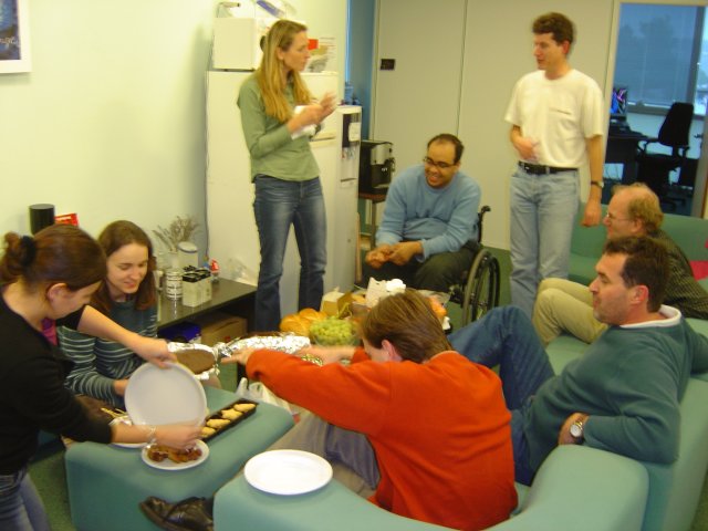 Alex, Caribou, Jessica, Shadi, Rigo, Bert, Daniel, Yves at the coffee area around cakes and sweets and fruit